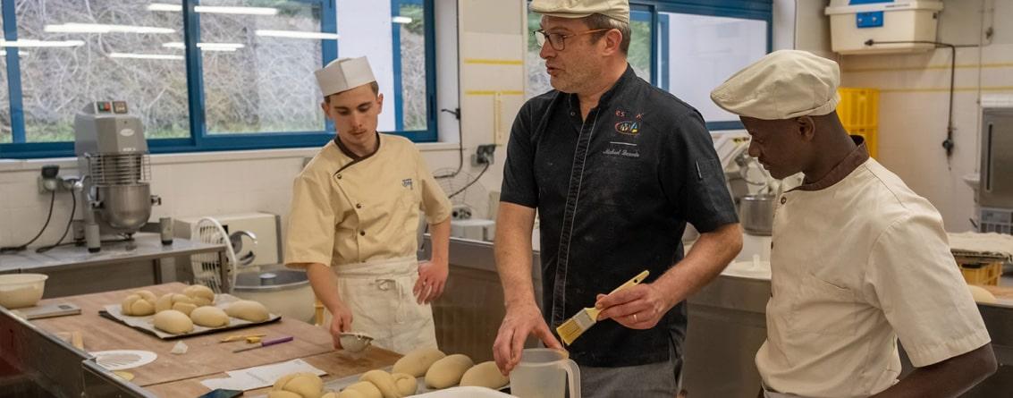 Professeur avec ses apprentis travaillant sur des pâtons