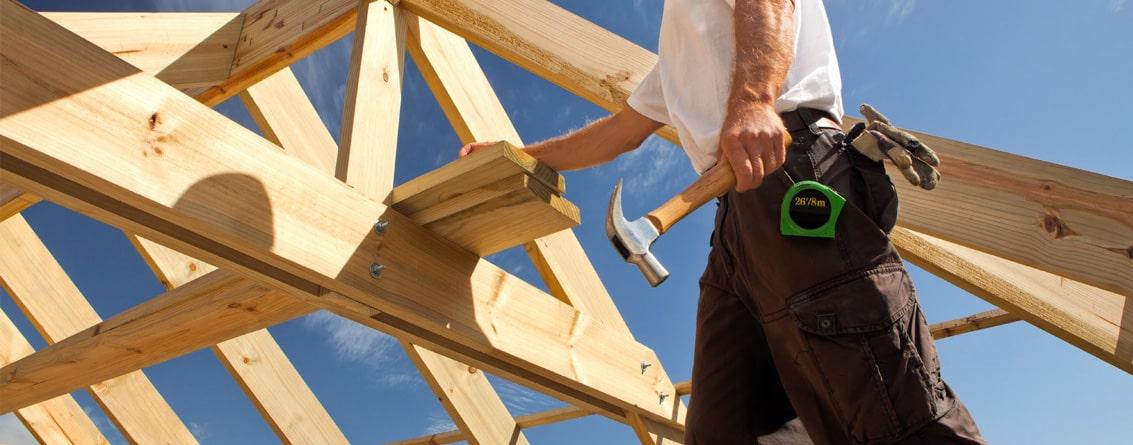 Homme sur la construction d'un toit avec des outils de charpentier
