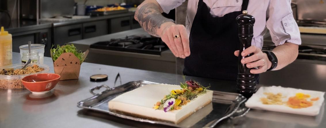 Un cuisinier peaufine le dressage d'un plat