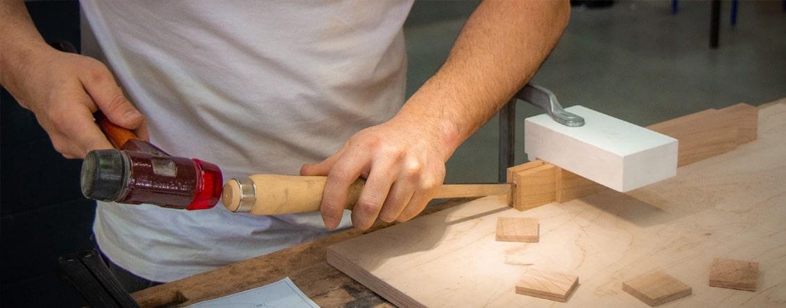 Apprenti travaillant sur la conception d'un meuble. ciseau à bois , maillet, étau
