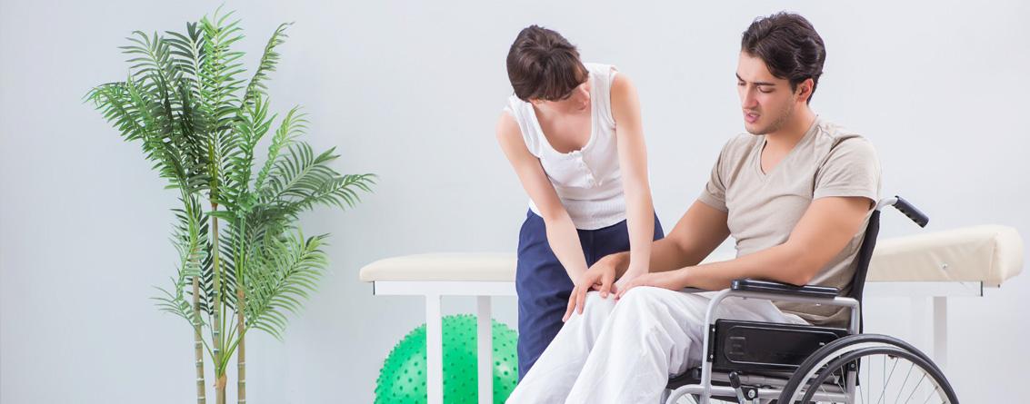 Jeune ergothérapeute en train d'échanger avec un patient en fauteuil roulant 