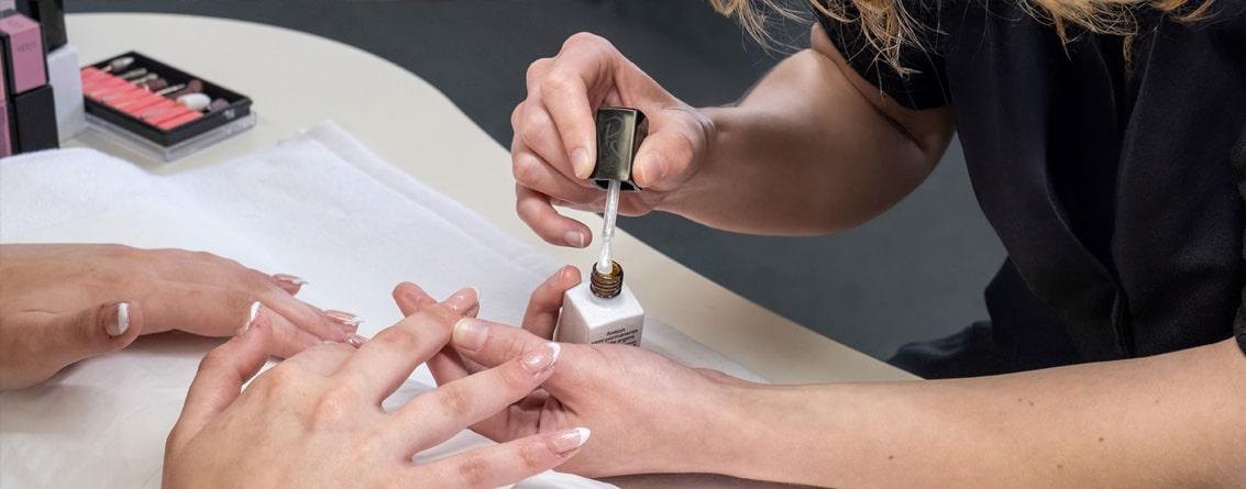 Une esthéticienne réalise une manicure