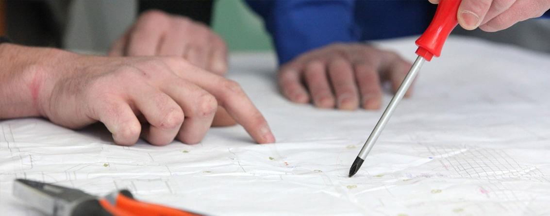 Mains sur un plan montrant un détaille
