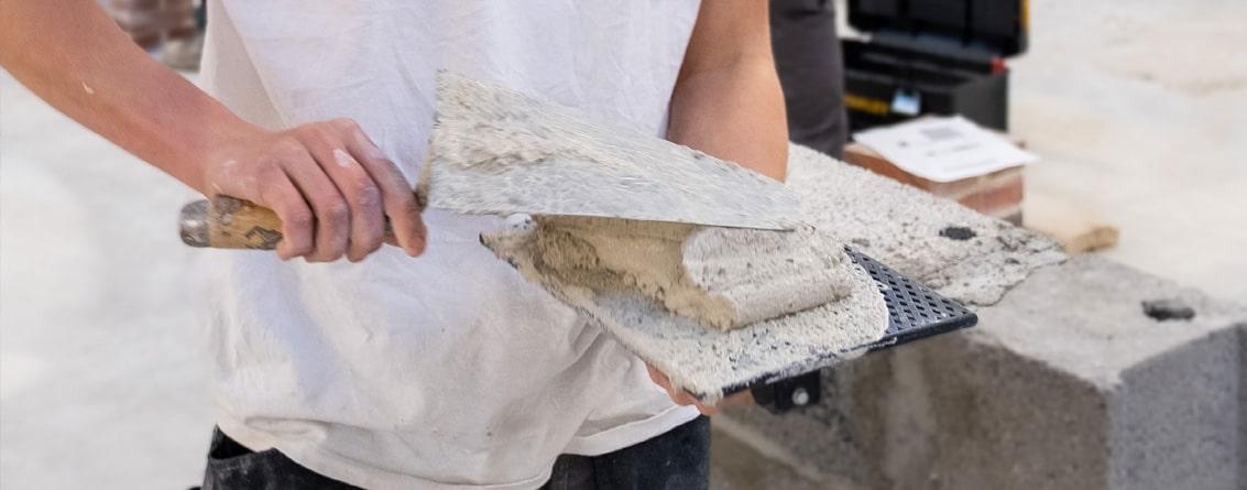 Apprenti maçon travaillant sur un mur | Béton - Parpaing