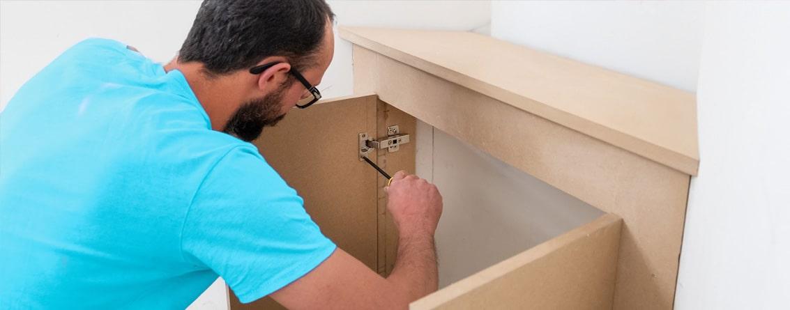 Homme en train d'installer un meuble sur mesure