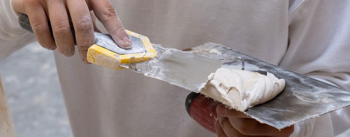 un jeune apprenti avec un couteau à enduire 