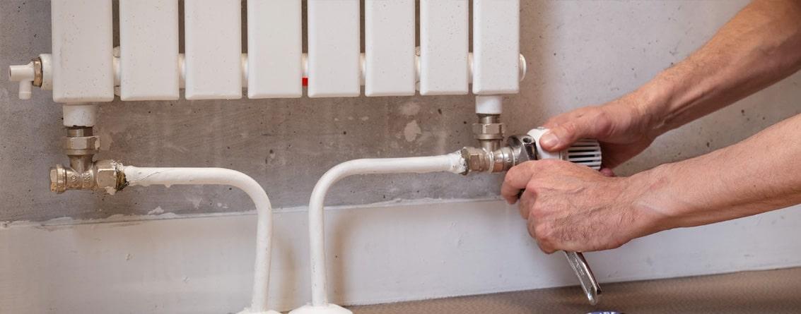 Homme en train de monter un radiateur à eau