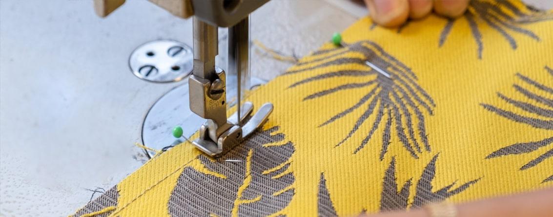 Un pied de machine a coudre sur un tissu épais de siège