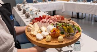 Serveur porte un plateau avec de la charcuterie et du fromage