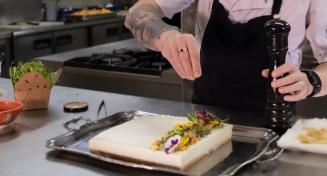 Un cuisinier peaufine le dressage d'un plat