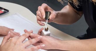 Une esthéticienne réalise une manicure
