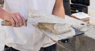 Apprenti maçon travaillant sur un mur | Béton - Parpaing