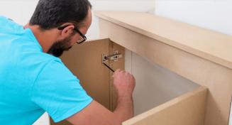 Homme en train d'installer un meuble sur mesure