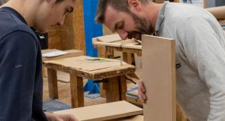 Un professeur et son apprenti travaillent sur la conception d'un meuble