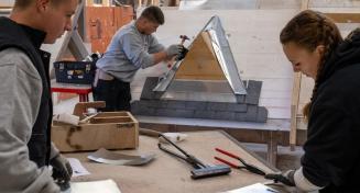 Jeunes apprentis travaillant sur des feuilles de zinc